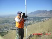 A man on the side of a hill doing a survey